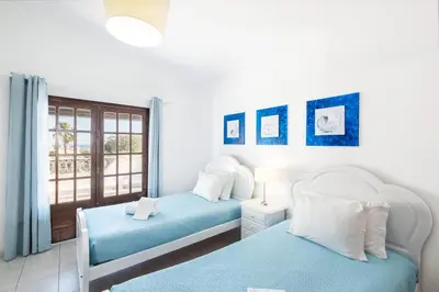 two twin beds in a room with a window at Patroves Ranch - private pool & sea views in Albufeira