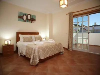 a bedroom with a bed and a large window at Villa Arade - Complex ideal for families in Albufeira