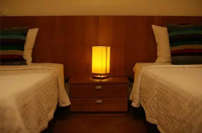 a lamp sitting on a night stand between two beds at Villa Arade - Complex ideal for families in Albufeira