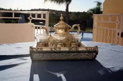 a silver tea kettle and two glasses on a table at Villa Arade - Complex ideal for families in Albufeira