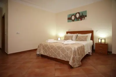 a bedroom with a large bed and a night stand at Villa Arade - Complex ideal for families in Albufeira