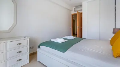 a white bedroom with a bed and a dresser at Sweet As by LovelyStay in Quarteira