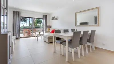 a dining room and living room with a table and chairs at Sweet As by LovelyStay in Quarteira