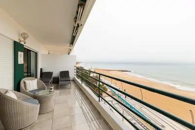 a balcony with chairs and a view of the beach at Seaview & Sunsets Apartment in Quarteira