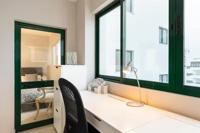 a room with a desk with two chairs and a window at Seaview & Sunsets Apartment in Quarteira