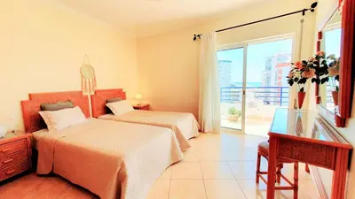 a bedroom with two beds and a desk and a window at Beach Lover's Paradise: 3BR 2 min from the Sand in Quarteira