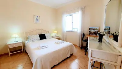 a bedroom with a large white bed with a window at Beach Lover's Paradise: 3BR 2 min from the Sand in Quarteira