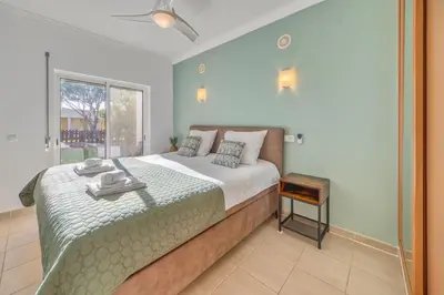 a bedroom with a large bed with a green blanket at Casa Serena, Portugal in Guia