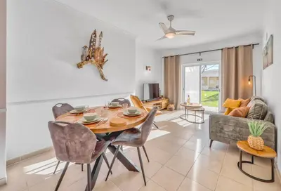 a dining room with a table and chairs and a couch at Casa Serena, Portugal in Guia