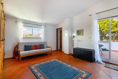 a living room with a couch and a window at Family Apartment Pool & Terrace in Vilamoura