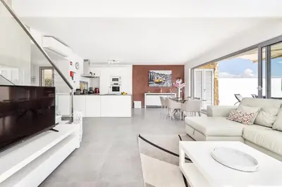 a living room with a white couch and a tv at Villa Jasmim by OCvillas in Albufeira