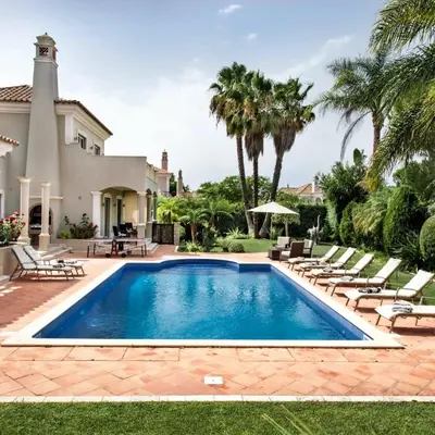 a swimming pool in front of a house at Villa Millennium luxury villa relaxing location in Almancil