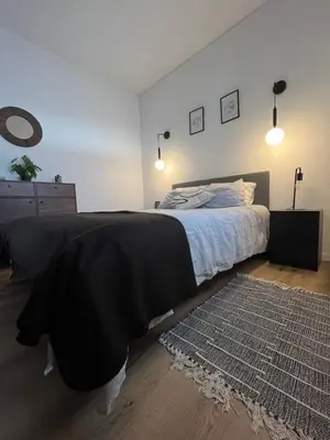 a bedroom with a bed with a black blanket and a rug at Apartamento Diago in Albufeira