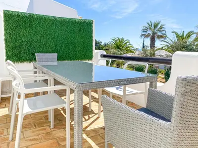 a table and chairs on the balcony of a house at Lovely Apartment in Albufeira 2BD 250m Beach Ocean view and AC Wi-Fi Pool in Albufeira