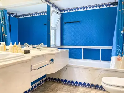 a blue bathroom with a toilet and a sink and a tub at Lovely Apartment in Albufeira 2BD 250m Beach Ocean view and AC Wi-Fi Pool in Albufeira
