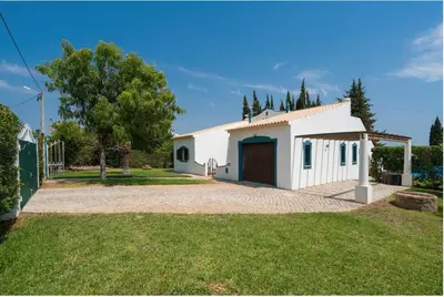 a white house with a garage in a yard at Villa Alegria in Loulé