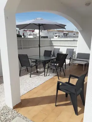 a patio with a table and chairs and an umbrella at Cozy apartment near Oura Beach in Albufeira