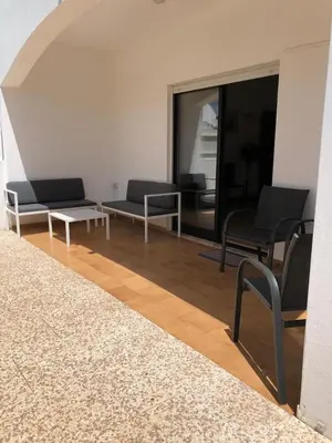a living room with couches and a table and chairs at Cozy apartment near Oura Beach in Albufeira