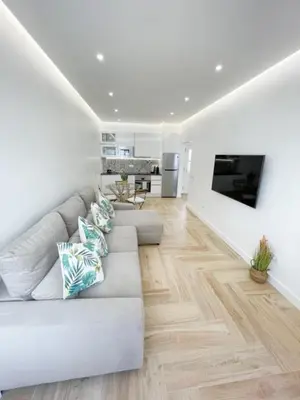 a living room with white walls and a couch at So Sweet Center of Faro Flat in Faro