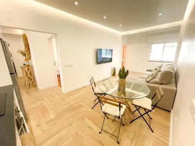 a living room with a glass table and chairs at So Sweet Center of Faro Flat in Faro
