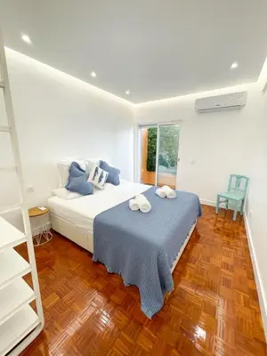 a bedroom with a bed with a blue blanket at So Sweet Center of Faro Flat in Faro