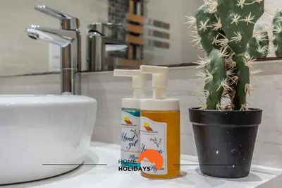 a bathroom counter with two bottles of sunscreen and a cactus at #120 T3 Espaçoso em Albufeira by Home Holidays in Albufeira
