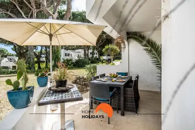 a patio with an umbrella and a table and chairs at #120 T3 Espaçoso em Albufeira by Home Holidays in Albufeira