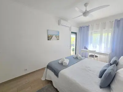 a bedroom with a bed and a ceiling fan at Modern Beach Apartment - Avenida Mar 1 - 150 mts da praia in Quarteira