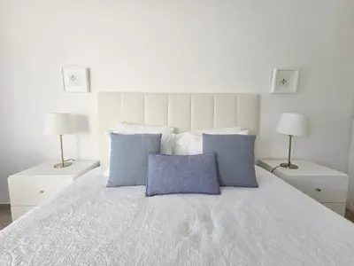 a bedroom with a large bed with a blue blanket at Modern Beach Apartment - Avenida Mar 1 - 150 mts da praia in Quarteira