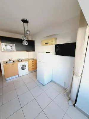 a kitchen with a refrigerator and a washing machine at T1, proche plage et commerces in Quarteira