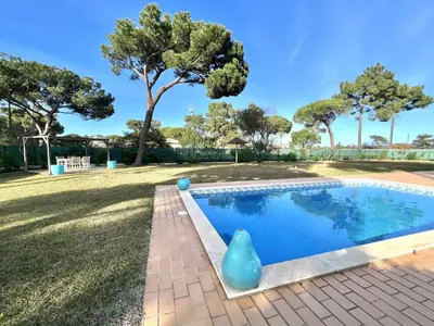 a swimming pool in a yard with trees in the background at Vila Caravela - Private Pool by HD Properties in Vilamoura