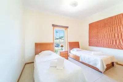 a bedroom with two beds and a window at Villa Gale Grande - bright airy property with a private pool in Albufeira