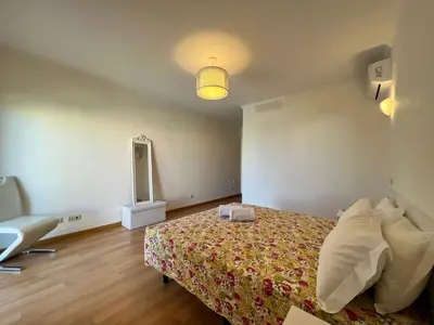 a bedroom with a bed and a chair in it at Apartment Filipa III - Beachfront with Jacuzzi in Albufeira