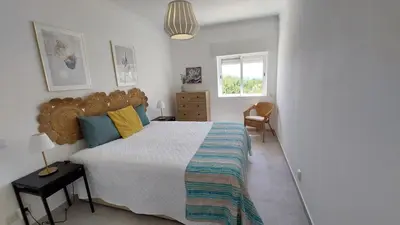 a bedroom with a large bed and a window at Apartamento Kélyfos Beach by feriascomsol in Quarteira