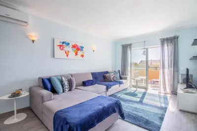 a living room with a couch and a window at Apartamento King in Vilamoura
