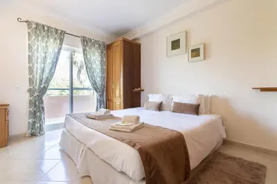 a bedroom with a large bed with two towels on it at Apartamento King in Vilamoura