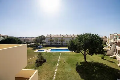 a view of a yard with a pool and a building at Apartamento King in Vilamoura