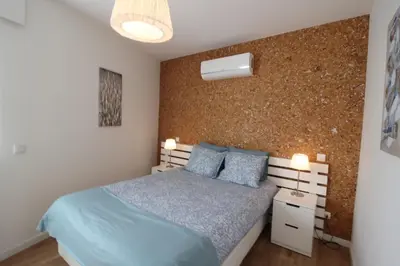 a bedroom with a blue bed and a brick wall at Downtown Villa in Faro