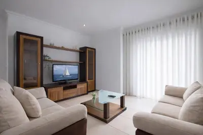 a living room with two couches and a tv at Apartamento Alameda in Quarteira