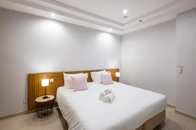 a bedroom with a large bed with white sheets and pink pillows at Villa Adaro - Large Luxury close to marina in Albufeira