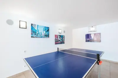 a ping pong table in a room with paintings at Villa Adaro - Large Luxury close to marina in Albufeira