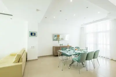 a dining room with a table and chairs and a couch at Villa Adaro - Large Luxury close to marina in Albufeira