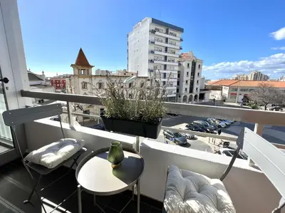 a balcony with a table and chairs and a view of a city at Vista by the Nest - City Center HD PROPERTIES in Faro