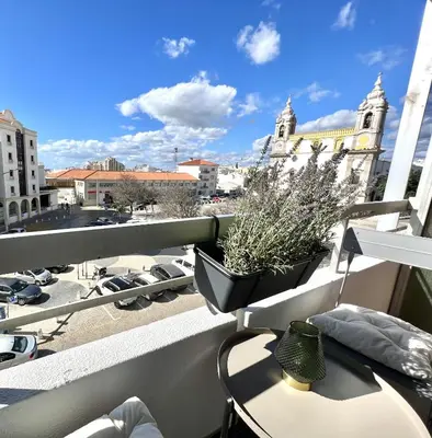 a balcony with a table and a view of a city at Vista by the Nest - City Center HD PROPERTIES in Faro