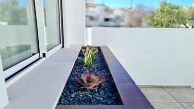a patio with a flower planter on a balcony at Marina Retreat - CleverDetails, for 2 adults and 2 children, Jacuzzi, near the Marina and the beach in Vilamoura