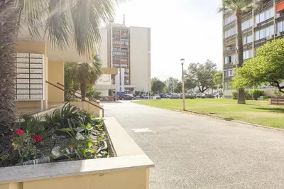 a street in a city with buildings and a palm tree at CORTEZ - Vilamoura in Vilamoura