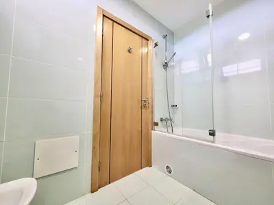 a bathroom with a toilet and a wooden door at Albufeira Forest View With Pool by Homing in Albufeira