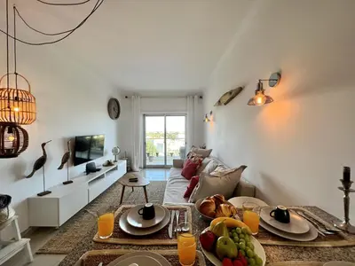 a living room with a couch and a table at Albufeira Forest View With Pool by Homing in Albufeira