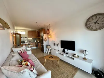 a living room with a couch and a clock on the wall at Albufeira Forest View With Pool by Homing in Albufeira