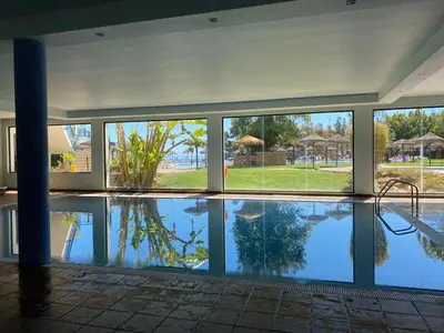 a large swimming pool in a building with a reflection in the water at Sunset Bliss in Albufeira - Short walk to Oldtown in Albufeira